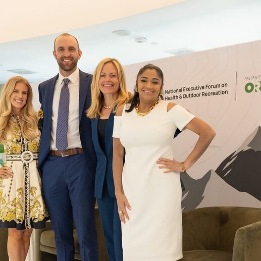 ORR_Team_Photo Three women and one man stand on a stage in business professional attire. The backdrop reads, "ORR."