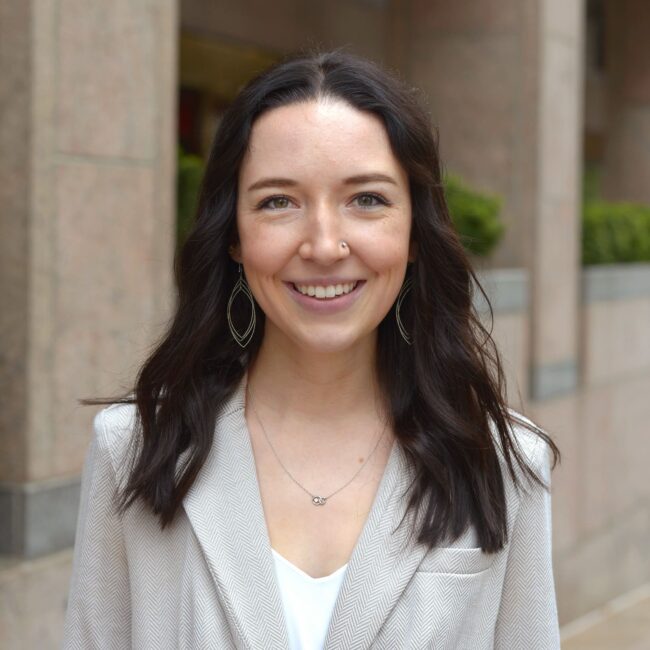68d2aaa44b0c75f742e64a36_ftf25-Team-Headshots-TaylorAnnWooley Woman smiling with gray blazer