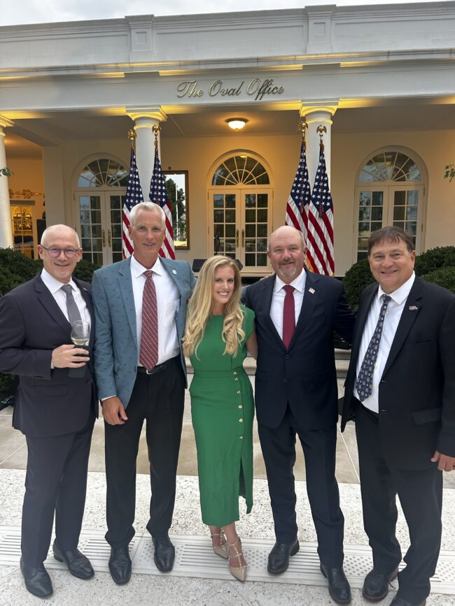 ORR White House Rose Garden Dinner Five people in suits pose outside of the Oval Office in Washington, D.C.